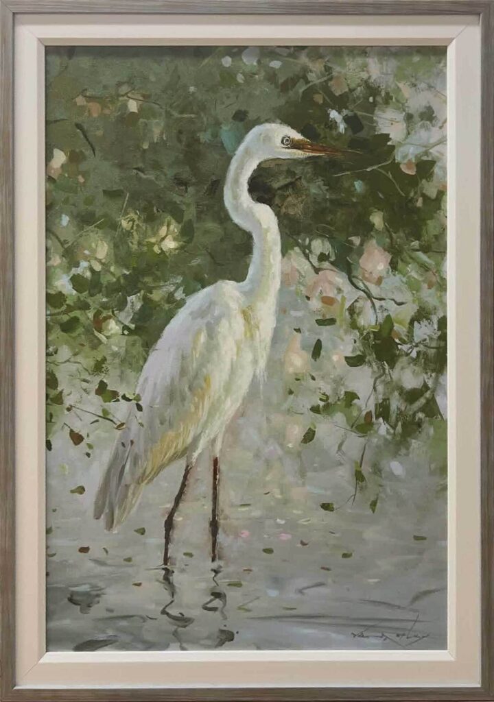 Framed painting of a white egret standing in shallow water amid green foliage
